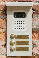 Fototapeta na wymiar Venice. Modern intercom on the wall of an old house. A fragment of brickwork with the fastening of the intercom bolts.