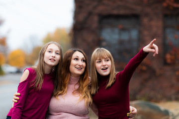 Teenager girls, Daughters and Mother smiling and hug together. Adorable Affection Casual Life Concept. showing something by hand