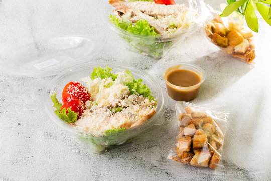 Chicken Caesar Salad with grilled chicken on plate. Grilled chicken breasts, tomatoes, fresh salad in plastic plate. isolated on white marble background.Selective focus. Hotizontal photo.