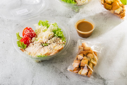 Chicken Caesar Salad with grilled chicken on plate. Grilled chicken breasts, tomatoes, fresh salad in plastic plate. isolated on white marble background.Selective focus. Hotizontal photo.