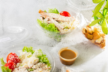 Chicken Caesar Salad with grilled chicken on plate. Grilled chicken breasts, tomatoes, fresh salad in plastic plate. isolated on white marble background.Selective focus. Hotizontal photo.