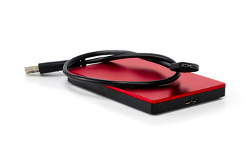 Red external hard drive disc with usb 3.0 cable. Best way of data storage on portable hdd. Close-up isolated on white surface with shadow.