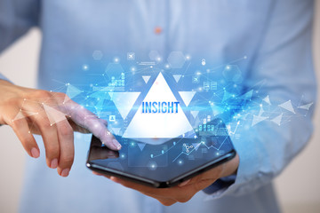 Businessman holding a foldable smartphone with INSIGHT inscription, business concept