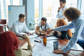 6 employees of both genders at a large and cozy office working actively, airy and light scenery,...