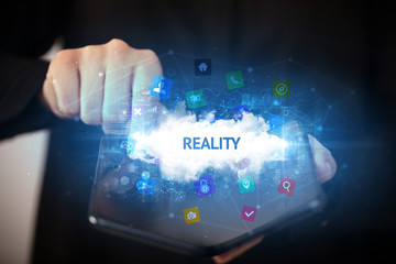 Businessman holding a foldable smartphone with REALITY inscription, technology concept