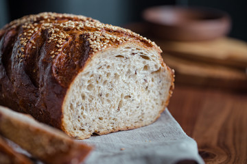 Whole grain loaf bread with chia seeds on a cutting board. Healthy eating concept.