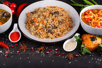 The concept of Eastern asian festive cuisine. Assorted Uzbek food set, pilaf, samsa, lagman, manti, shurpa restaurant concept Eastern arabic new year and Christmas dish from lamb served cookware.