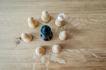 Chess pieces on a wooden table. Symbolic meaning. Beautiful figures on an oak wood background.