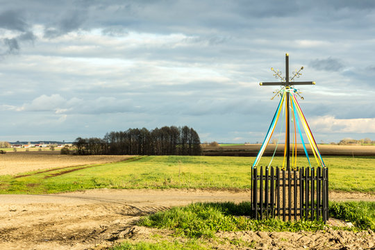 Late autumn. A cross standing at the crossroads, among fields and meadows.  Close-up. Old Christian tradition. Podlasie, Poland.