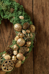 Eco decor. Green wreath with golden nuts and cones.