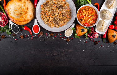 The concept of Eastern asian festive cuisine. Assorted Uzbek food set, pilaf, samsa, lagman, manti, shurpa restaurant concept Eastern arabic new year and Christmas dish from lamb served cookware.