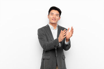 young chinese man feeling happy and successful, smiling and clapping hands, saying congratulations...