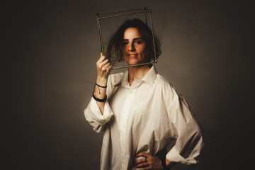 portrait of a girl in a white shirt with a metal cube-cage on his head. isolate. The concept of estrangement, the man in a case