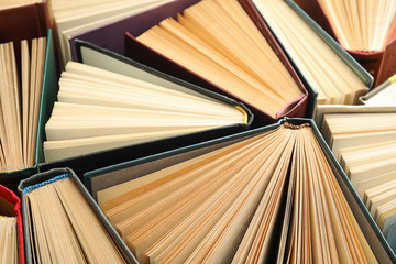Many different hardcover books as background, closeup