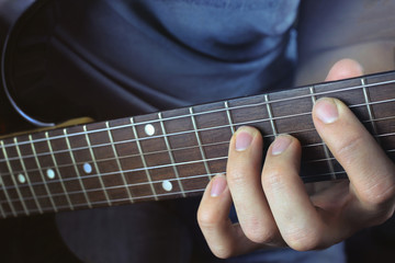 Obraz na płótnie Canvas Man playing electric guitar, hand close-up