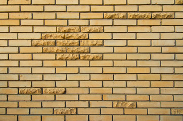 Wall of yellow silicate brick. There are several decorative bricks with a chipped rustic edge. Background. Texture.