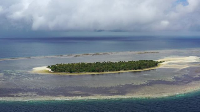 The idyllic, tropical island of Koon, in the Ceram Sea, lies in the path of a windy squall. The dramatic reefs around this remote island are full of schooling fish and corals.
