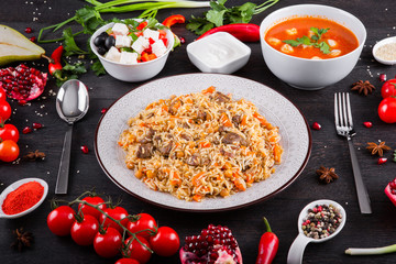 The concept of Eastern asian festive cuisine. Assorted Uzbek food set, pilaf, samsa, lagman, manti, shurpa restaurant concept Eastern arabic new year and Christmas dish from lamb served cookware.