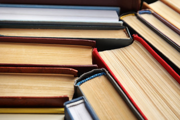 Many different hardcover books as background, closeup