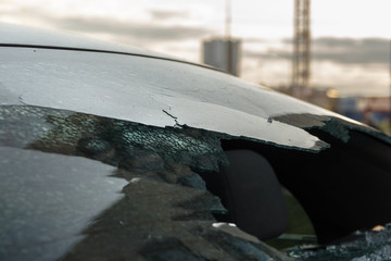 Broken rear glass of car, spread fragments of glass on asphalt