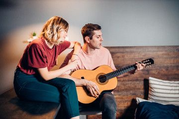 Obraz premium two friends sit playing the guitar, relax and enjoy performing music, using acoustic guitar instrument
