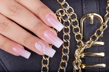 Hand with long artificial manicured nails with ombre gradient design in pink and white colors © natkinzu