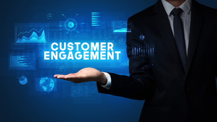 Hand of Businessman holding CUSTOMER ENGAGEMENT inscription, business success concept