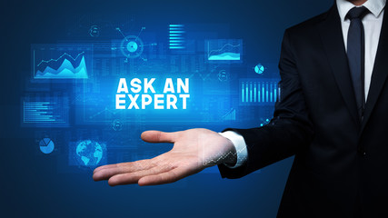 Obraz premium Hand of Businessman holding ASK AN EXPERT inscription, business success concept
