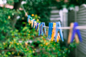 Fototapeta na wymiar Colored clothespins on a long rope. Clothespins for drying clothes
