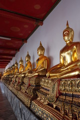 Gilded statues of Buddha sitting in lotus position. Statues from a Buddhist monastery.