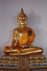 Gilded Buddha statue sitting in lotus position. Statue from a Buddhist monastery.