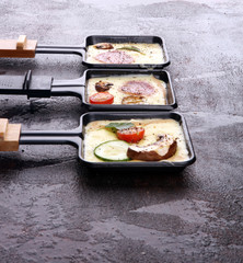 Delicious traditional Swiss melted raclette cheese on diced boiled or baked potato.