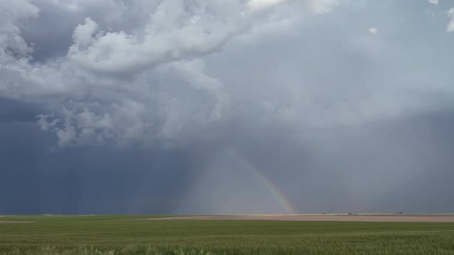 Time lapse of rainbow forming durning storm moving through the grassy pains in tornado season.