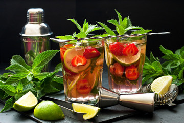 Cool strawberry mojito  cocktail in glasses on  dark table