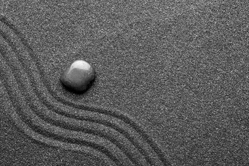 Fototapeta na wymiar Zen garden stone on black sand with pattern, top view