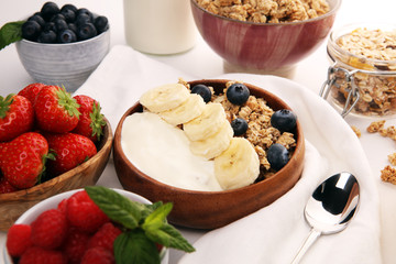 Tasty homemade granola served on table. Healthy breakfast with a bowl of oatmeal with banana, blueberries, strawberries and healthy food for Breakfast