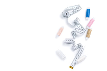 Design composition of twisted white measuring tape and scattered colored threads with empty place for text isolated on white background
