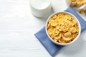 Tasty corn flakes on white wooden table, flat lay. Space for text