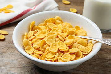 Tasty crispy corn flakes on wooden table