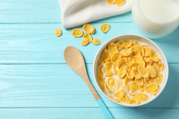 Flat lay composition with tasty corn flakes on light blue wooden table