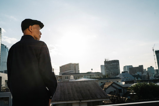 屋上にいる、ハンチング帽を被ったシニア男性のポートレート