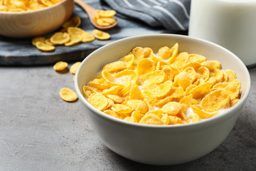 Tasty corn flakes with milk on light grey table