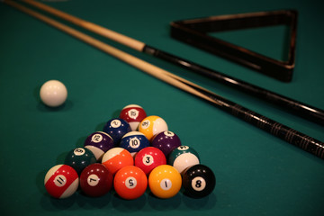 Sports game of billiards on a green cloth. Multi-colored billiard balls in the form of a triangle...