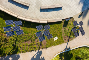 Green energy Aerial flight in a city park overlooking a panel with solar cells surrounded by trees....