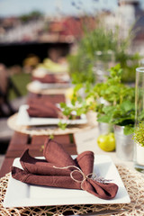 table setting in rustic style with herbs, apples and brown napkins