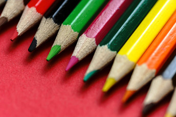Fototapeta premium Color Pencils on red background. Colored Pencils Background. Crayons Close Up. - Image