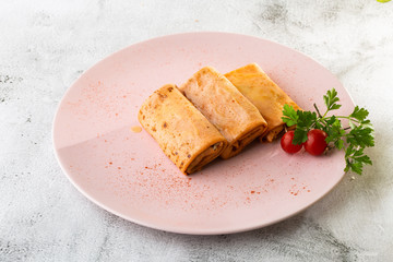 Savory crepe rolls with ground meat filling served with tomatoes. Traditional Russian Shrovetide Maslenitsa festival meal isolated on white marble background. Homemade food. . Hotizontal photo.