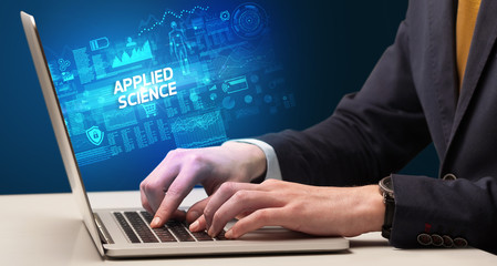 Obraz na płótnie Canvas Businessman working on laptop with APPLIED SCIENCE inscription, cyber technology concept