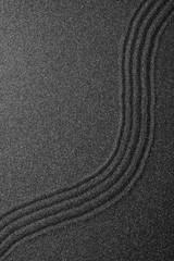 Black sand with beautiful pattern, top view. Zen concept