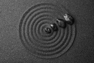 Foto op Plexiglas Stenen in het zand Zwart zand met stenen en mooi patroon, plat gelegd. Zen-concept